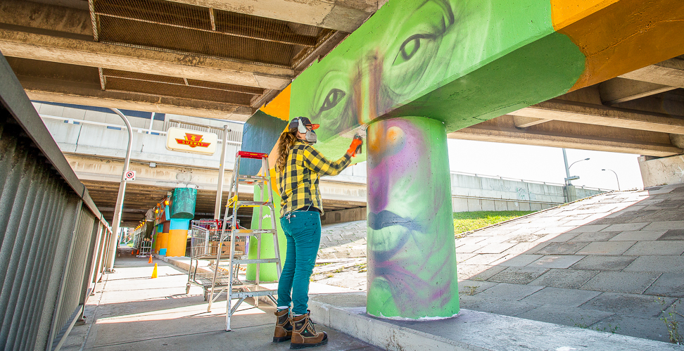 Image of the artist painting the mural at Wilson Station