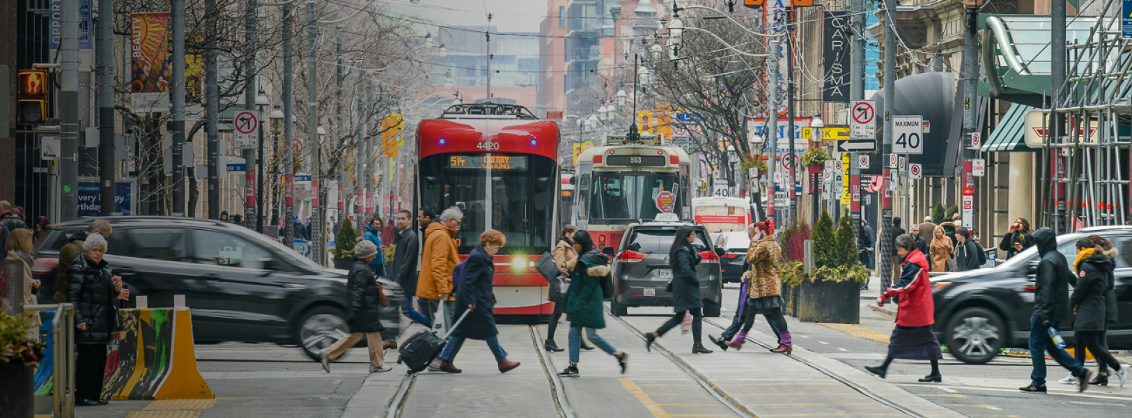 Image of two streetcars on a busy downtown street