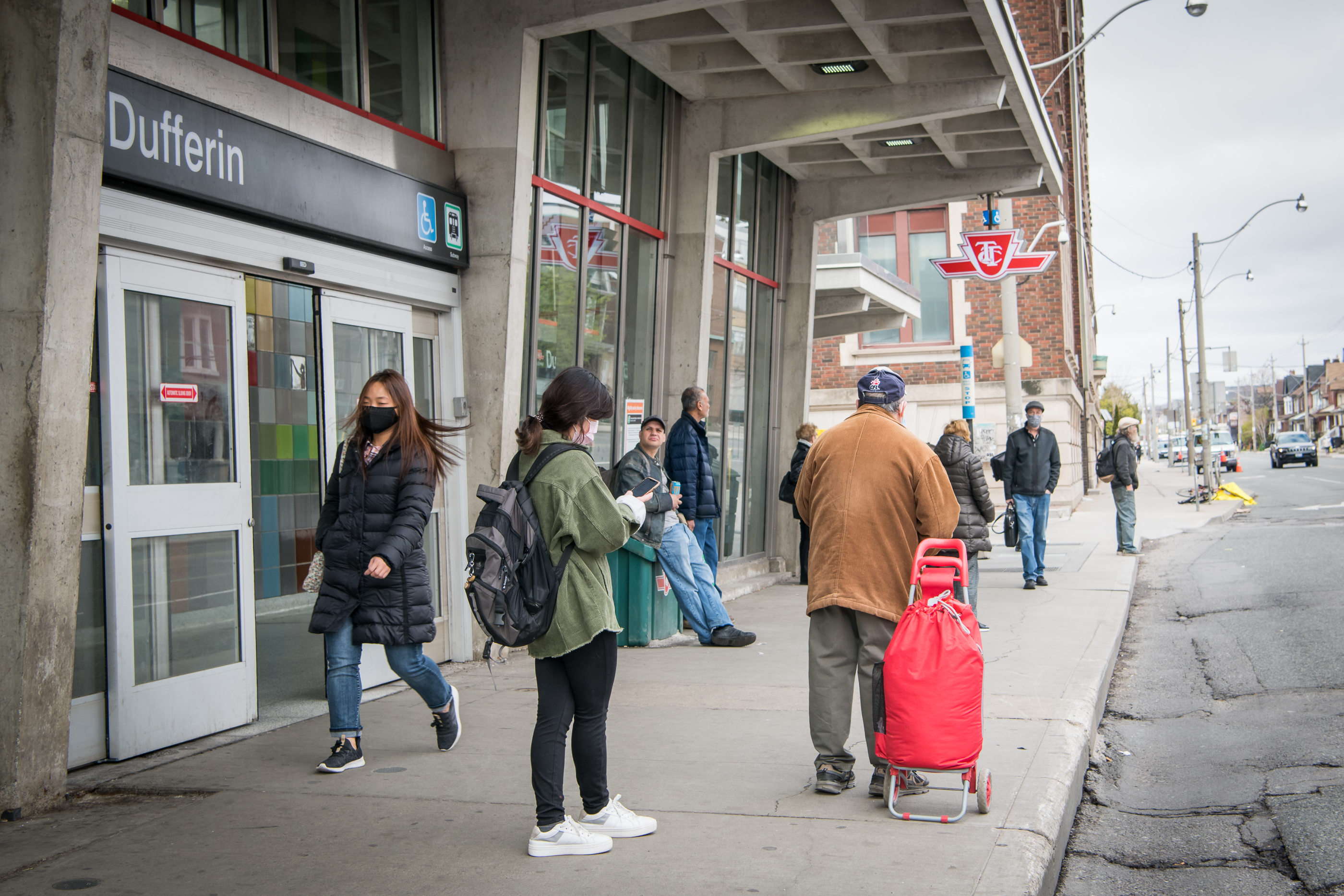 Image of customers waiting for a bus and entering Dufferin station