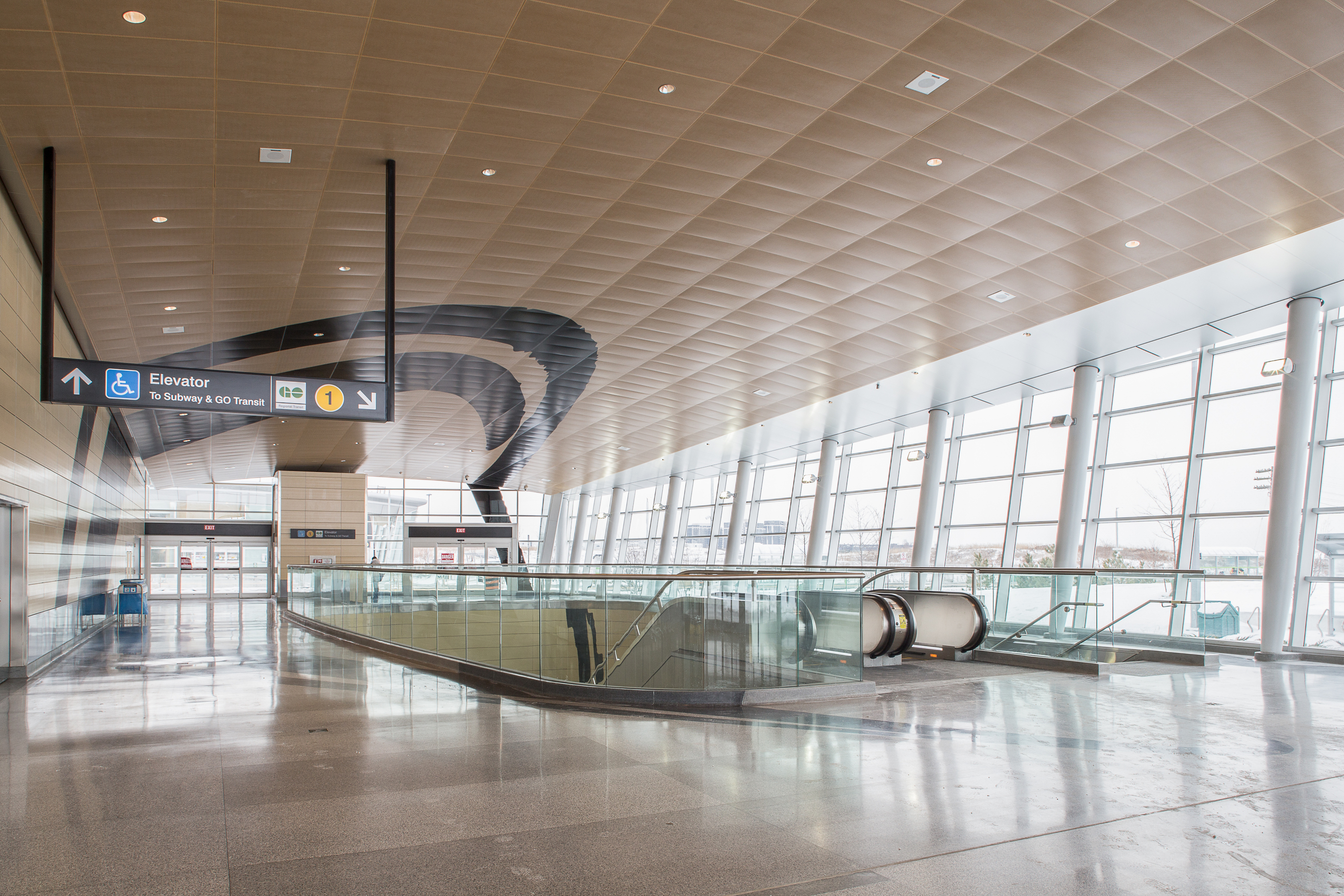 Interior of Downsview Park station with stairs and escalators leading down to the subway.