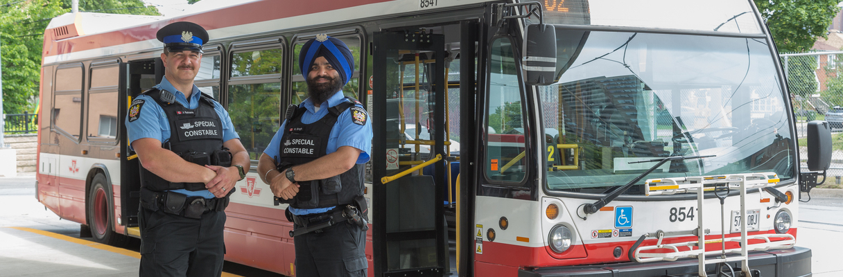 Two TTC Special Constables in front of a bus