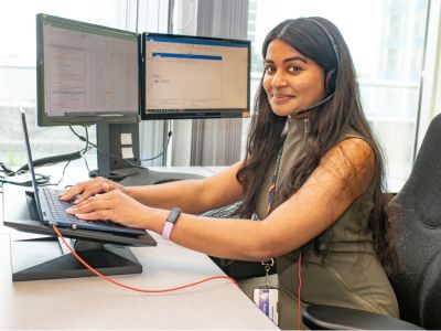 Woman sitting at a desk typing on a computer