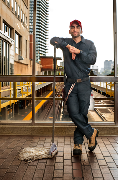 Janitor in front of subway station window with the caption "You are the reason we shine".