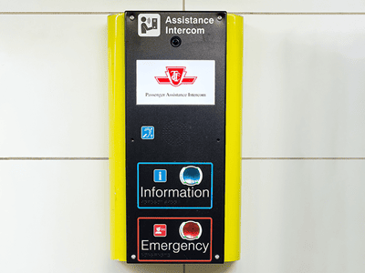A yellow and black Passenger Assistance Intercom with blue and red buttons for Information and Emergency.
