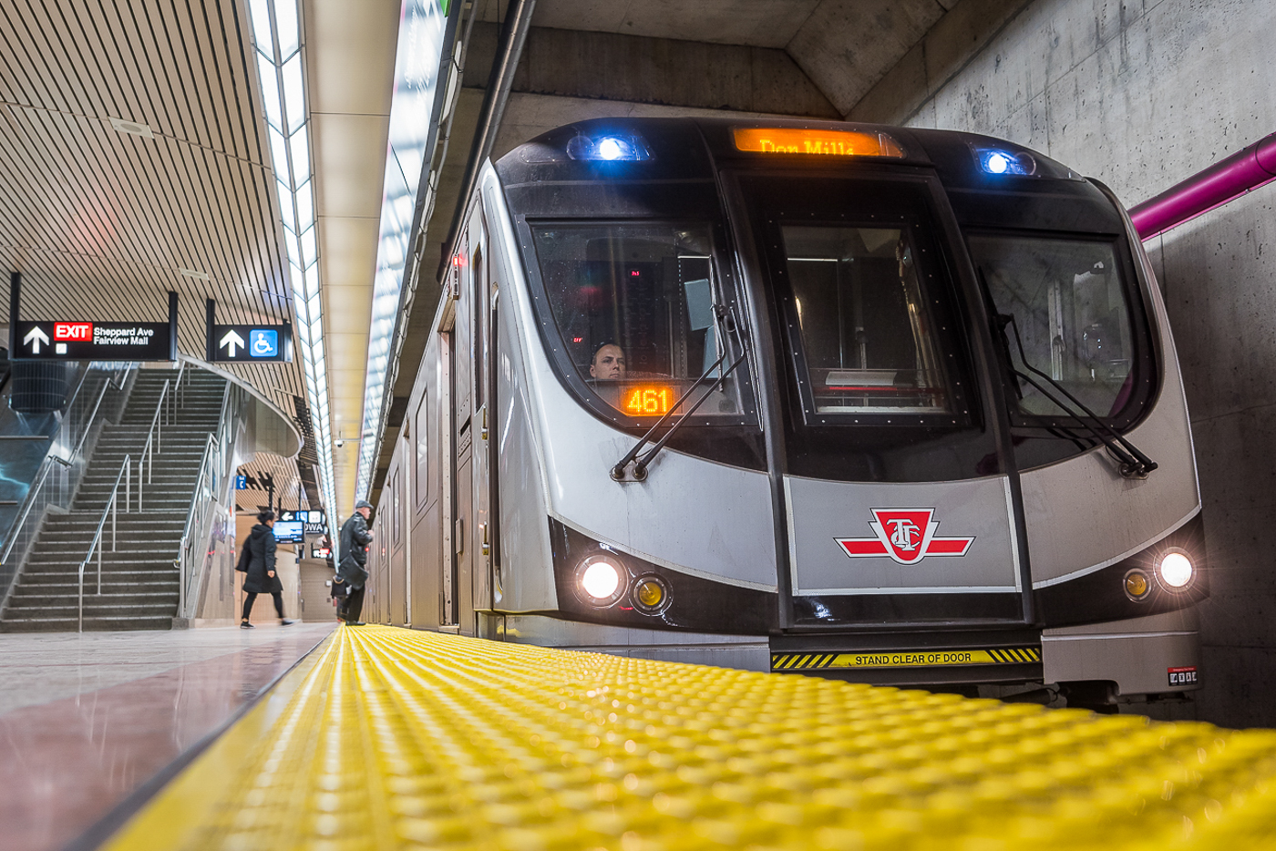 Close-up of a black and grey TTC subway train pulling up to a yellow platform