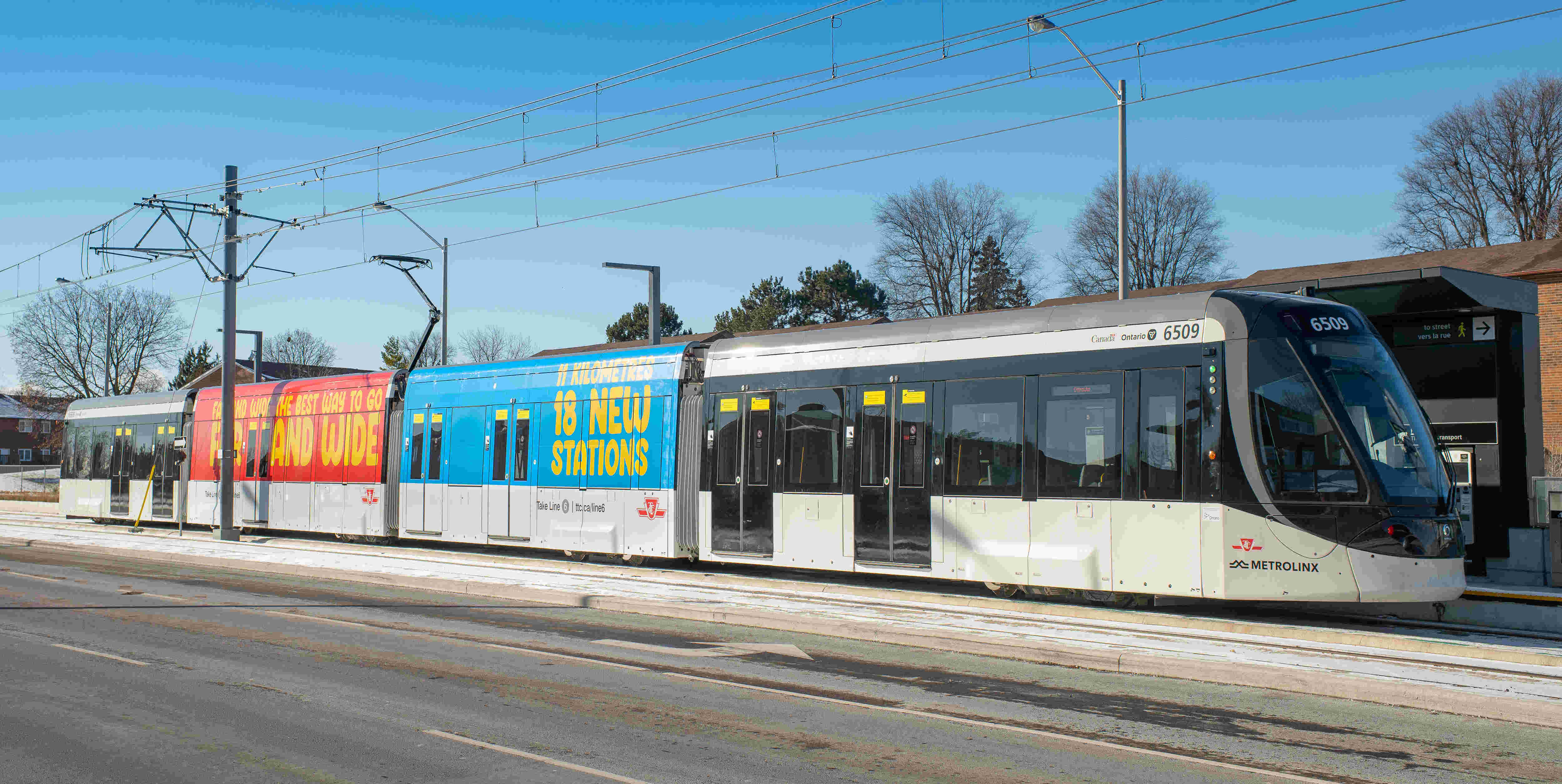 Line 6 car stopping at a surface level stop.