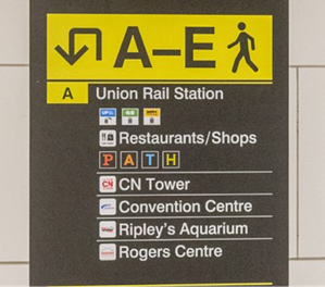 Close up of a black and yellow exit code sign at Union Station. The sign is for exists A to E, and shows destinations in zone A – Union Rail Station, including Restaurants/Shops, CN Tower and Convention Centre.