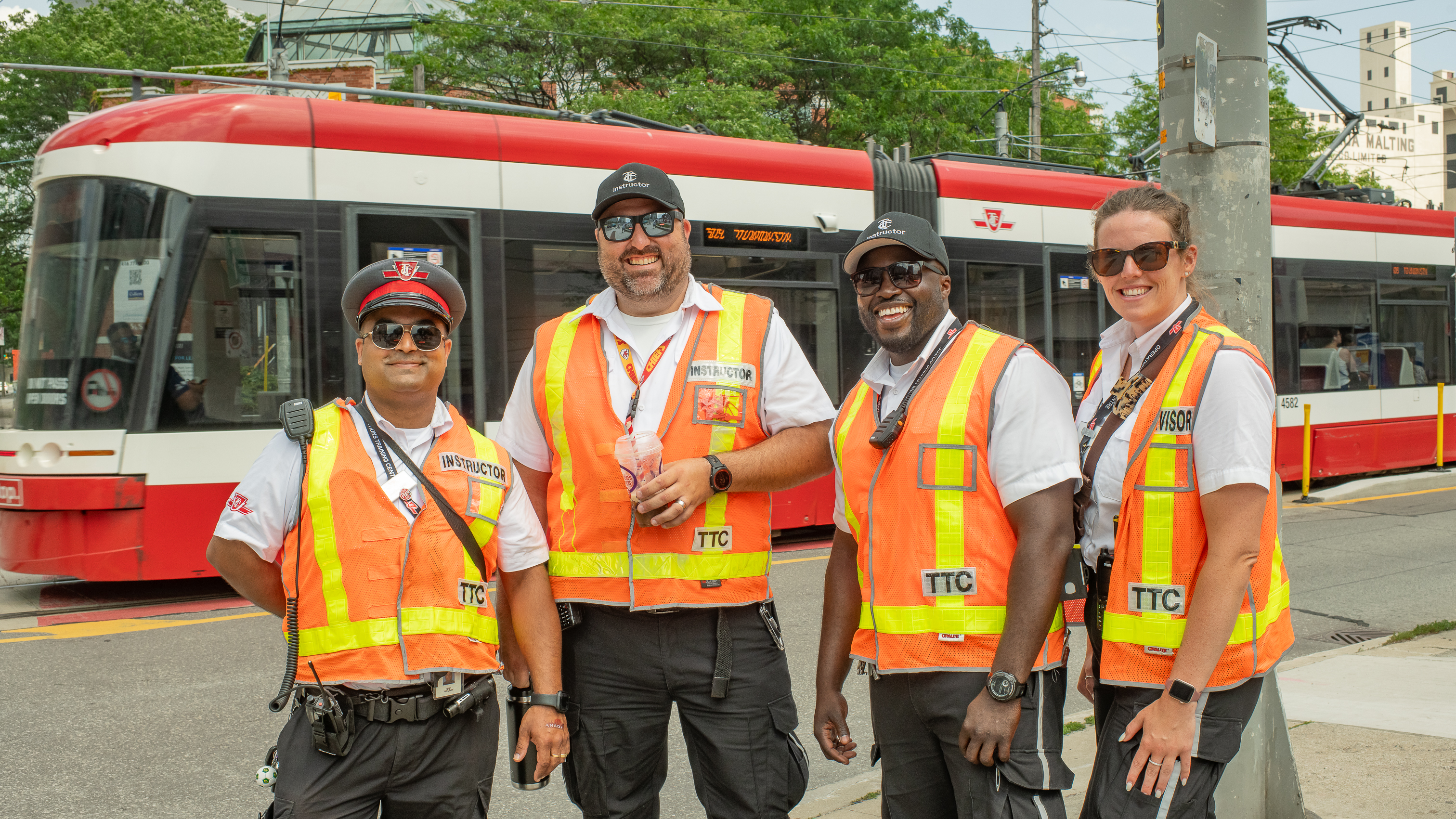 TTC employees posing in front of a TTC streetcar. 