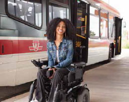 Customer on bus platform with bus in the background