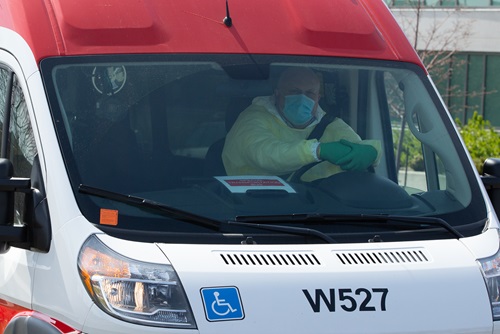 Wheel-Trans driver in a vehicle, wearing a protective mask