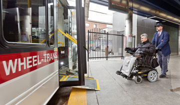 A Wheel-Trans operator assisting a customer board a Wheel-Trans bus