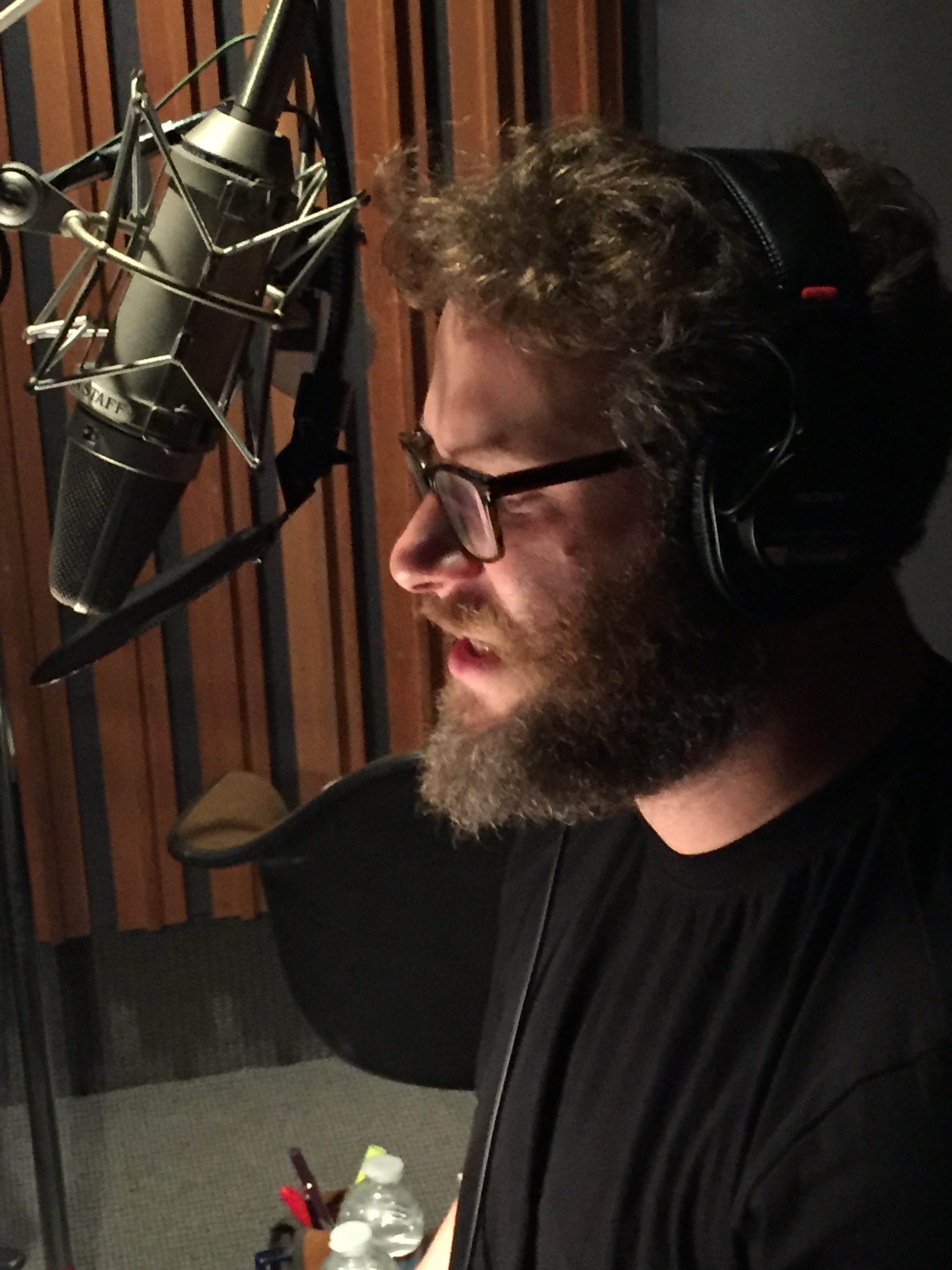 Seth Rogen recording in front of a microphone.